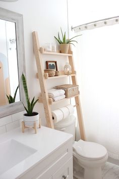 a bathroom with a ladder leaning up against the wall next to a toilet and sink