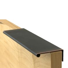 a close up of a black metal bar on a wooden board with wood grained edges