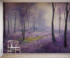 a chair sitting in front of a wall mural with purple flowers and trees on it