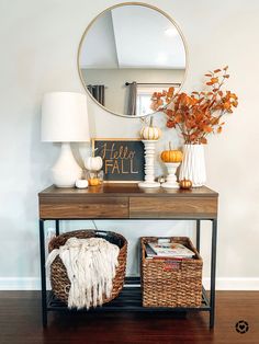 a console table with two wicker baskets and a mirror on the wall above it