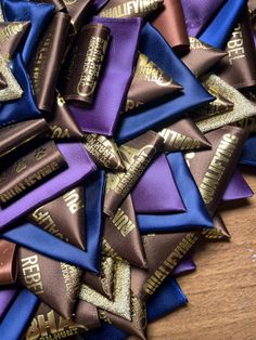 a pile of purple and blue ribbons on top of a wooden table