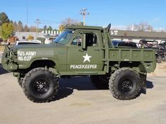 an army green truck parked in a parking lot