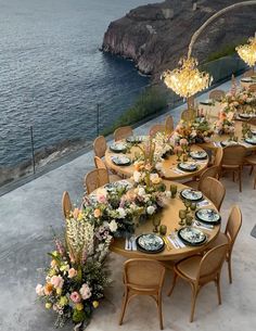 an outdoor dining area with tables and chairs set up for a formal dinner overlooking the ocean