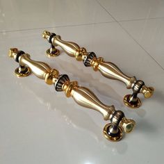 two shiny gold handles and knobs on a white counter