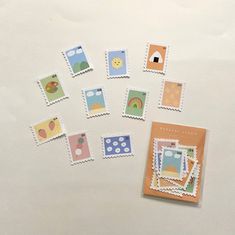 some stamps are laying next to each other on a white surface with an open book