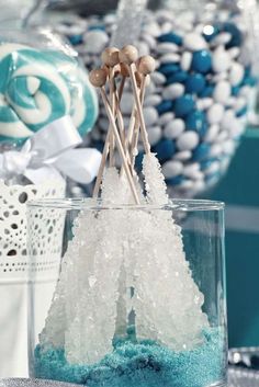 blue and white desserts are displayed in glass vases with sticks sticking out of them