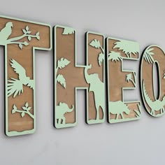 there is a wooden sign that says hello with animals and palm trees on the letters