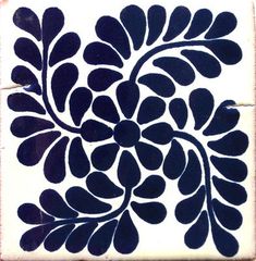 a black and white tile with an artistic design on it's side, in the shape of a flower