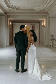 a bride and groom standing in an empty hallway