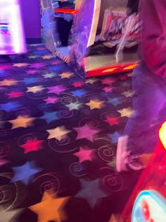 a person standing next to an inflatable ball on top of a colorful floor