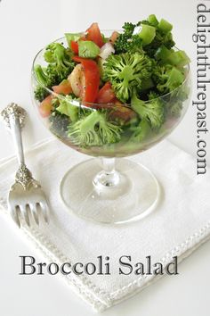 broccoli salad in a glass bowl on a napkin with a fork and spoon