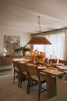 a dining room table is set with candles and flowers