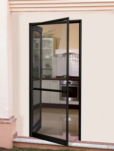 an open glass door leading to a kitchen with white walls and tile flooring on the outside