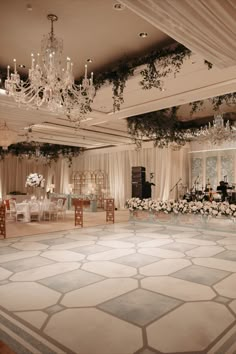 an empty ballroom with chandeliers and tables