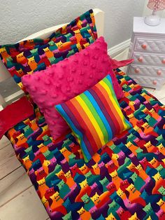 a bed with colorful sheets and pillows on it