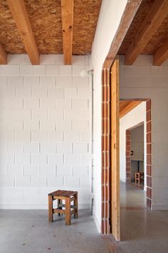 an empty room with wooden beams and white walls