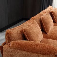 a brown couch with several pillows on it