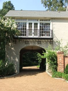 a brick building with an arched doorway leading into the yard