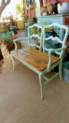 two wooden chairs sitting next to each other in a room filled with pots and plants