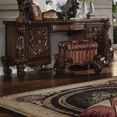 an ornate wooden desk and chair in a living room