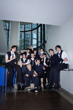 a group of young men in suits and ties posing for a photo on the stairs