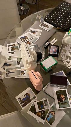 a glass table topped with pictures and other items on top of it's surface