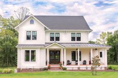 a large white house sitting on top of a lush green field