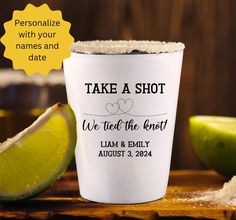 a shot glass with the words take a shot on it next to limes and salt