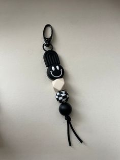 a black and white beaded keychain hanging on a wall