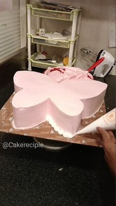 a large pink cake sitting on top of a table