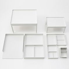 several white boxes are arranged on a table top, including one with compartments and the other with dividers