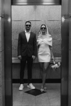 a man and woman standing in an elevator