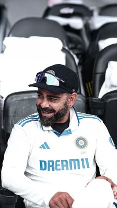 a man with a beard sitting in a stadium