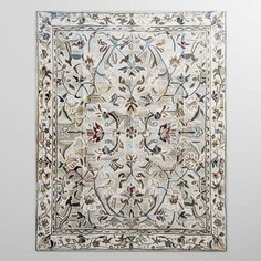 an intricately designed rug hanging on the wall