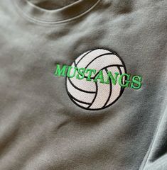 a gray sweatshirt with green lettering on it