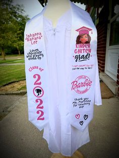 a white shirt with pink lettering on the front and back is hanging from a mannequin's head