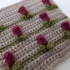 a crocheted square with pink roses on it