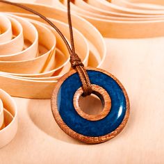 a blue and brown pendant on a string next to some white bowls filled with paper