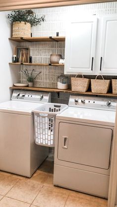 a washer and dryer sitting next to each other in a room with white cabinets