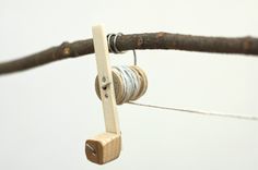 a close up of an object made out of wood and thread on a stick with two spools attached to it