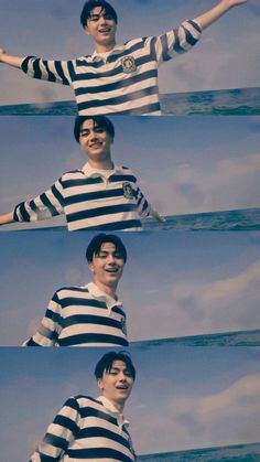 a man in striped shirt standing on top of the ocean with his arms out and smiling