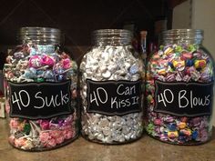 three glass jars filled with candy sitting on top of a counter