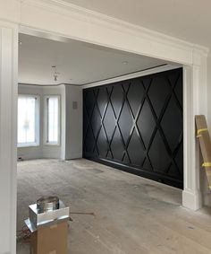 an empty room with black and white wallpaper in the middle, surrounded by construction materials