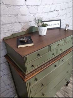 a green dresser with a potted plant on top