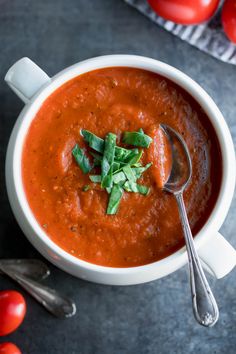 a white bowl filled with tomato soup and garnish