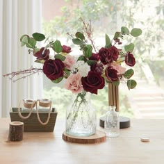 a vase filled with flowers sitting on top of a wooden table next to other items