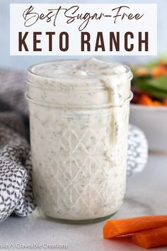 a glass jar filled with dressing next to carrots