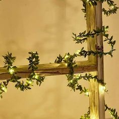 a wooden ladder decorated with lights and greenery