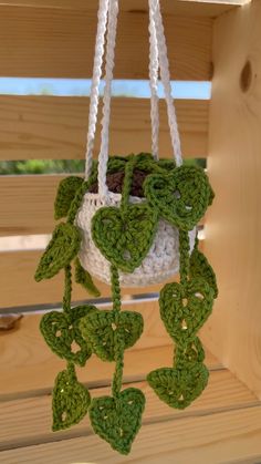 a crocheted hanging planter with green leaves