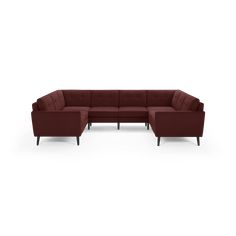 a red sectional couch with wooden legs and arm rests on an isolated white background,